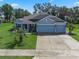 Charming single-story home featuring a well-manicured lawn and a three-car garage at 1640 Marsh Pointe Dr, Clermont, FL 34711