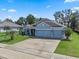 Beautiful one-story home with lush green lawn and a spacious three-car garage at 1640 Marsh Pointe Dr, Clermont, FL 34711