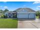 Charming one-story home with a well-manicured lawn, two-car garage, and inviting front porch at 1640 Marsh Pointe Dr, Clermont, FL 34711