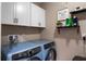 Laundry room featuring modern, front-loading washer and dryer, and white cabinets at 1640 Marsh Pointe Dr, Clermont, FL 34711