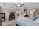 Comfortable main bedroom features a tray ceiling, ceiling fan, fireplace, and an area rug at 1640 Marsh Pointe Dr, Clermont, FL 34711