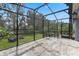 Screened patio with stone pavers, comfortable seating, and serene backyard view at 1640 Marsh Pointe Dr, Clermont, FL 34711