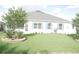 Back yard with lush green lawn and blue shuttered windows at 1676 Van Buren Way, The Villages, FL 32162