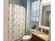 Updated bathroom with granite countertop, decorative shower curtain, and ample lighting at 1676 Van Buren Way, The Villages, FL 32162