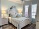 Comfortable bedroom with coastal decor, ample natural light, and hardwood floors at 1676 Van Buren Way, The Villages, FL 32162