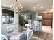Charming dining area with round table, chandelier, and view of kitchen and living area at 1676 Van Buren Way, The Villages, FL 32162