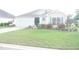 Charming home featuring a well-manicured lawn and colorful landscaping at 1676 Van Buren Way, The Villages, FL 32162