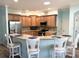 Well-equipped kitchen with breakfast bar, granite countertops, and stainless steel appliances at 1676 Van Buren Way, The Villages, FL 32162