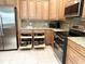 Bright kitchen with pull out drawers, stainless steel appliances, and tiled floor at 1676 Van Buren Way, The Villages, FL 32162