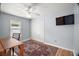 Cozy bedroom with ceiling fan, area rug, window, closet and mounted flat screen TV at 16827 Se 92Nd Lance Ct, The Villages, FL 32162