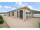 Home's back patio with beige concrete and exterior features sliding glass doors at 16827 Se 92Nd Lance Ct, The Villages, FL 32162