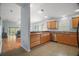 Open-concept kitchen featuring stainless steel appliances and wood cabinets, seamlessly flowing into the living area at 16827 Se 92Nd Lance Ct, The Villages, FL 32162