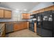 Well-lit kitchen with stainless steel dishwasher and black appliances, complemented by light wood cabinetry at 16827 Se 92Nd Lance Ct, The Villages, FL 32162