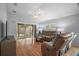 Bright living room with hardwood floors, vaulted ceiling, and sliding glass doors to the enclosed patio at 16827 Se 92Nd Lance Ct, The Villages, FL 32162