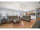 Spacious living room with wood floors, ceiling fan, and access to an open kitchen area at 16827 Se 92Nd Lance Ct, The Villages, FL 32162