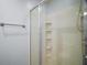 Shower featuring a clear glass door and convenient corner shelving at 16827 Se 92Nd Lance Ct, The Villages, FL 32162