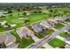 Aerial view of the property on a golf course with mature trees and landscaping at 1706 Augustine Dr, The Villages, FL 32159