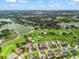 Aerial view of a home on a golf course community with a lake and trees, offering scenic views and recreation at 1706 Augustine Dr, The Villages, FL 32159