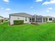 Well-maintained backyard featuring lush green grass and a screened-in patio, perfect for outdoor relaxation at 1706 Augustine Dr, The Villages, FL 32159
