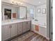 Bathroom with double sinks, soaking tub, large mirror, and walk-in closet at 1706 Augustine Dr, The Villages, FL 32159