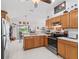 Bright eat-in kitchen features wood cabinets, white countertops, and stainless steel appliances at 1706 Augustine Dr, The Villages, FL 32159