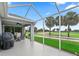 Screened patio overlooking a golf course featuring an outdoor table, chairs, and grill at 1706 Augustine Dr, The Villages, FL 32159