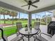 Screened patio overlooking a golf course featuring an outdoor table and chairs at 1706 Augustine Dr, The Villages, FL 32159