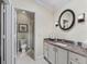 Bathroom with a round mirror over the sink and a walk-in shower with glass doors at 17324 Se 82Nd Pecan Ter, The Villages, FL 32162