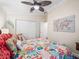 Bright bedroom with a ceiling fan, closet, tropical bedding, and a world map wall decoration at 17324 Se 82Nd Pecan Ter, The Villages, FL 32162