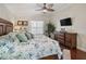 Bright main bedroom with a decorative ceiling fan, hardwood floors, and a wall-mounted television at 17324 Se 82Nd Pecan Ter, The Villages, FL 32162