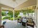 Relaxing covered patio with wicker furniture, overhead awning, and views of the landscaped yard at 17324 Se 82Nd Pecan Ter, The Villages, FL 32162