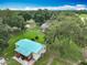 Aerial view of a home with a blue metal roof, screened pool, fenced yard, and mature trees on a large lot at 17670 Se 283Rd Ave, Umatilla, FL 32784