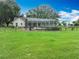A large, verdant green, fenced backyard on a sunny day at 17670 Se 283Rd Ave, Umatilla, FL 32784