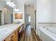 Bathroom with double sinks, walk-in shower, and soaking tub, combining convenience with relaxation at 17670 Se 283Rd Ave, Umatilla, FL 32784