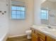 Cozy bathroom with a bathtub, wood vanity, and window providing natural light at 17670 Se 283Rd Ave, Umatilla, FL 32784