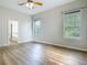 Bright bedroom with wood-look floors and large windows, offering a serene and inviting space at 17670 Se 283Rd Ave, Umatilla, FL 32784