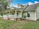 Charming home featuring a covered porch with fans, dormer windows, and landscaped front yard with white picket fence at 17670 Se 283Rd Ave, Umatilla, FL 32784