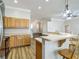 Open kitchen featuring wood cabinets, breakfast bar, and wood-look floors, offering a cozy and functional design at 17670 Se 283Rd Ave, Umatilla, FL 32784