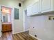 Functional laundry area with storage cabinets, utility connections, and easy access to bathroom at 17670 Se 283Rd Ave, Umatilla, FL 32784