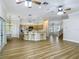 Bright open-concept living space with hardwood floors, a kitchen island, and elegant lighting fixtures at 17670 Se 283Rd Ave, Umatilla, FL 32784