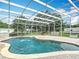 Screened in pool with water feature and brick paver decking overlooking the verdant green backyard at 17670 Se 283Rd Ave, Umatilla, FL 32784