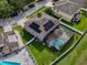 Aerial view of a house with a screened pool and solar panels, set in a fenced yard at 1861 Remembrance Ave, St Cloud, FL 34769