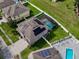 Aerial view of home featuring a screened-in pool and solar panels on the roof in a landscaped neighborhood at 1861 Remembrance Ave, St Cloud, FL 34769