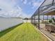 Backyard featuring green grass and a screened lanai with outdoor furniture on a brick patio at 1861 Remembrance Ave, St Cloud, FL 34769