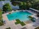 Aerial view of a large community pool with lounge chairs, landscaping, and a lake backdrop at 1861 Remembrance Ave, St Cloud, FL 34769