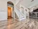 Inviting entryway with wood-look floors, staircase, and arched doorways leading to other rooms at 1861 Remembrance Ave, St Cloud, FL 34769