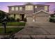 Twilight view of a two-story home featuring a two-car garage, landscaped yard, and inviting entrance at 1861 Remembrance Ave, St Cloud, FL 34769