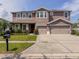 Spacious two-story home with a three-car garage, a red door, solar panels and a well-maintained lawn at 1861 Remembrance Ave, St Cloud, FL 34769