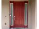 Elegant red front door with sidelights and modern hardware, offering a warm welcome at 1861 Remembrance Ave, St Cloud, FL 34769