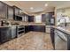Modern kitchen featuring dark cabinets, granite countertops, and stainless steel appliances at 1861 Remembrance Ave, St Cloud, FL 34769